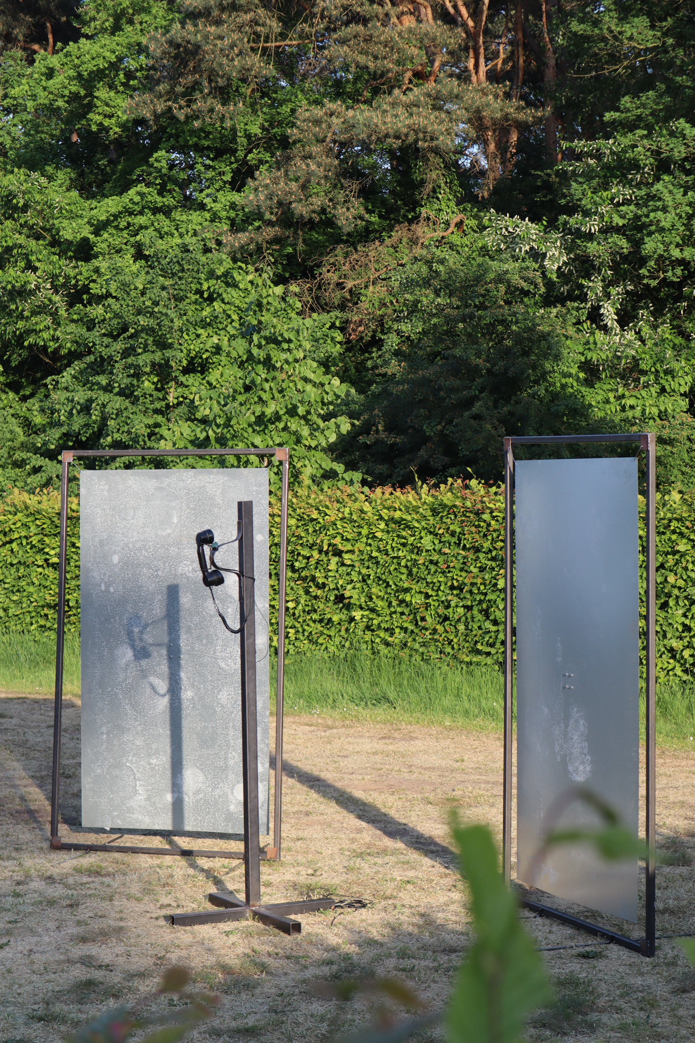 Phone on a metal pole with a red light ontop of it